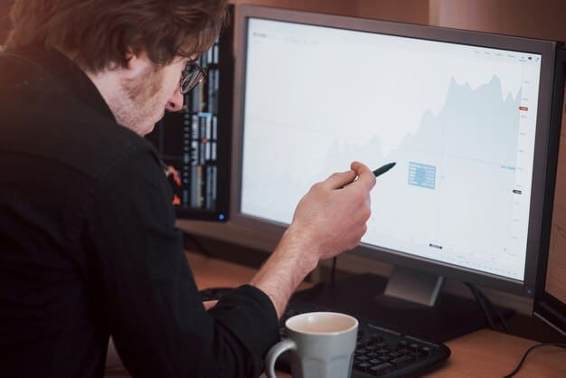 Close-up of a financial analyst reviewing data on a computer screen, showing charts and graphs indicating positive trends in investment funds.