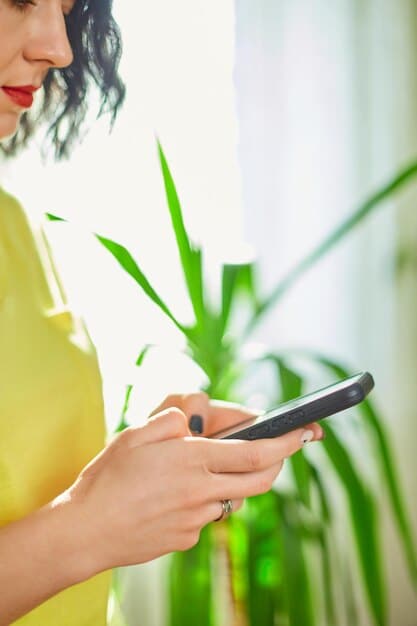 A close-up shot of a person using a mobile banking app on their phone, with a green leaf subtly integrated into the app's design. The background is blurred, focusing on the phone screen.