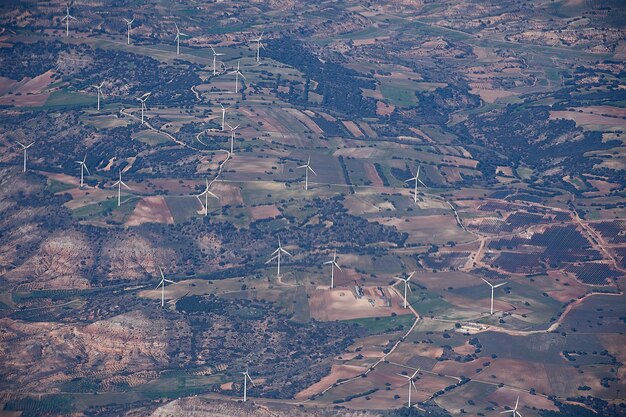 An aerial shot of a wind farm in Portugal, showcasing the country's commitment to renewable energy. The wind turbines are set against a backdrop of rolling hills and clear skies, emphasizing the natural beauty and sustainability of the region.