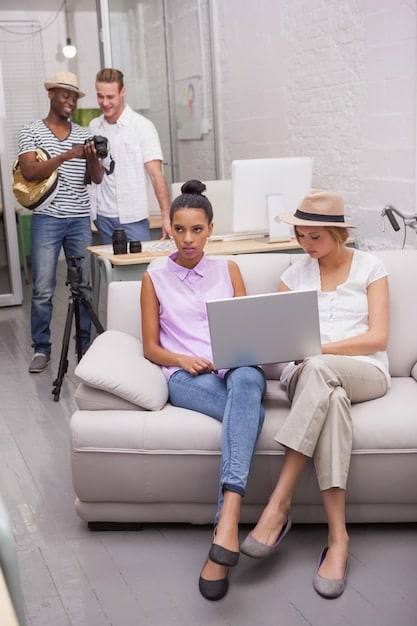 A medium shot capturing a diverse group of family members in a bright, modern office, listening attentively to a financial advisor. The advisor is gesturing towards a tablet displaying estate planning information.