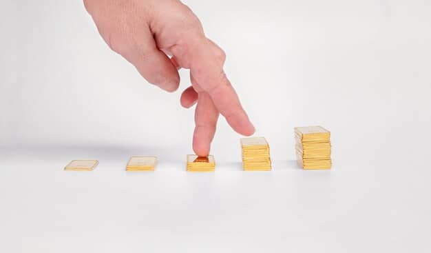 A close-up shot of a hand placing a miniature ladder against a stack of gold coins, symbolizing the step-by-step growth of wealth through dividend reinvestment.