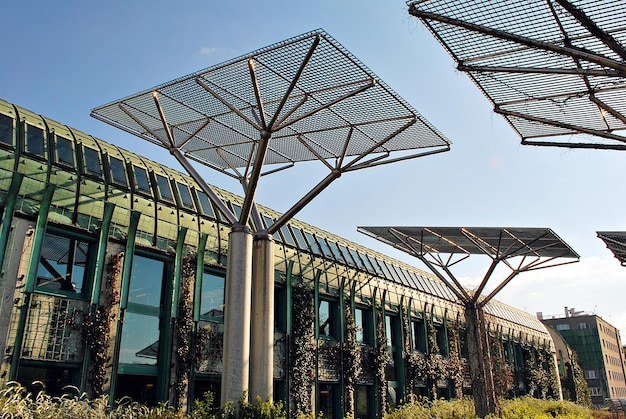 A modern office building with solar panels on the roof in Lisbon, Portugal. The image should highlight sustainable technology and investment in green energy.